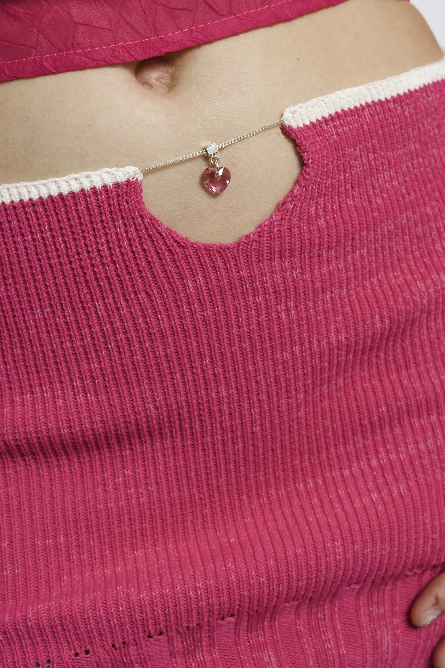 MaisonCléo Jupes>RUNWAY LOOK 30 – Mini jupe rose fuchsia tricotée avec fentes et piercing coeur